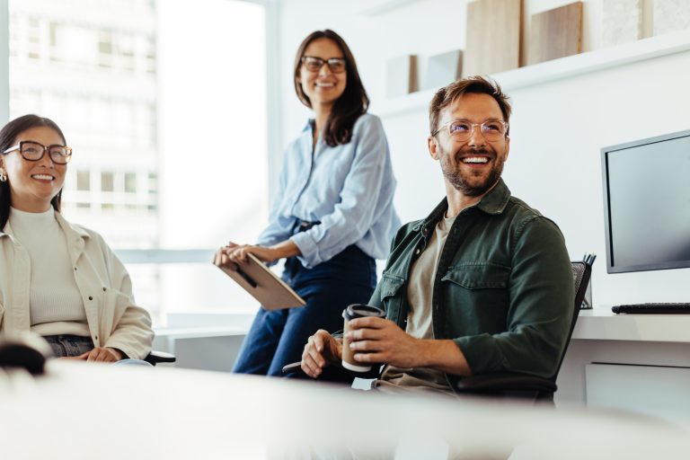 Professionals listening to a discussion in an office. Group of happy business people having a team meeting.